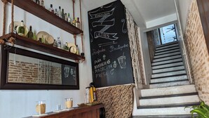 A bar area with wooden shelves, a chalkboard menu, and a staircase. - Walled City 2-bedroom 2-bath Condo with Patio (Cartagena de Indias)
