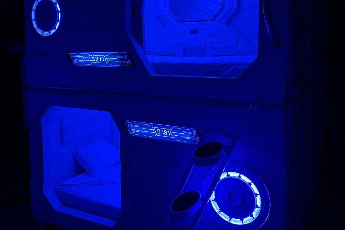 A room with a futuristic design, featuring a central control panel with illuminated buttons and a digital display.
