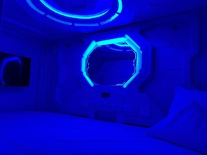 A room with a futuristic design, featuring a hexagonal window and a bed. - Green Caps Cancún Hospedaje (Cancun)