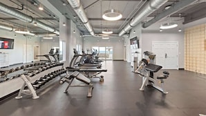 A gym with exercise equipment, mirrors, and a large window. - Family favorite! On the beach! Amazing amenities! (Orange Beach)