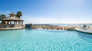 A clear blue pool with a gazebo and a wooden deck. - Family favorite! On the beach! Amazing amenities! (Orange Beach)