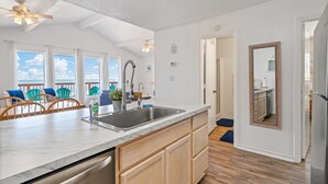 A kitchen with a large island, wooden cabinets, and a view of the ocean. - Beach House · Oceanfront 4BR, Peaceful, Cozy, Kids/Pet Friendly! (Freeport)