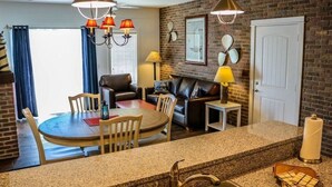 A compact living space with a dining area, a sofa, and a kitchen counter.