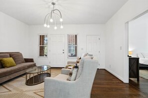 Relax in this stylish living room with a sofa, armchair, and glass coffee table.