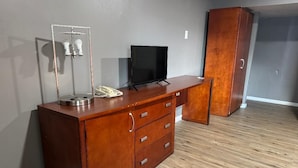 A wooden dresser with drawers and a flat-screen TV on top. - Budget Inn New Cumberland-Harrisburg-Hershey-York (New Cumberland)