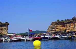 Boats are moored near the rocky coastline, offering stunning views of the surrounding cliffs.