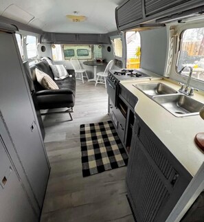 Cozy interior with a kitchenette, seating area, and storage.