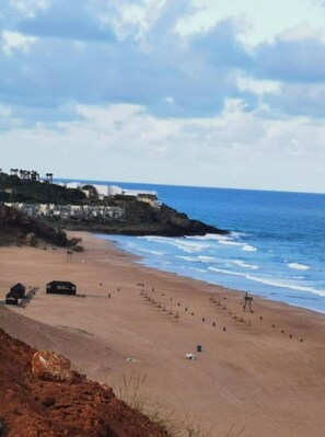 Na praia, espreguiçadeiras, toalhas de praia 