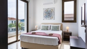A bedroom with a bed, two bedside tables, a window, and a ceiling fan.