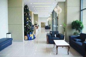 En moderne lobby med juletræ, siddeområde og reception.