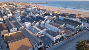 Una zona residencial costera con casas a lo largo de la playa, un muelle y una vista despejada del océano.