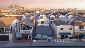 Un barrio residencial con casas que tienen porches, antenas parabólicas y una vista despejada del océano.