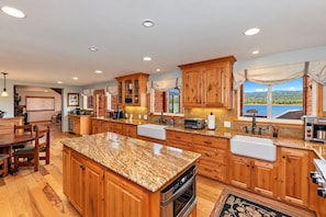 A spacious kitchen with wooden cabinets, granite countertops, and a large island.