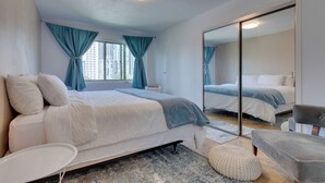 Un dormitorio moderno con una cama grande, una mesita de noche, una silla y un espejo.