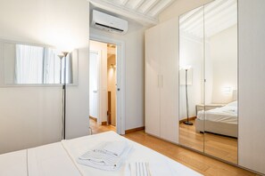 Une chambre d’hôtel équipée d’un lit, d’un miroir, d’une armoire et d’un appareil de climatisation.
