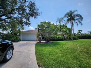 Set amidst mature trees, this property offers a serene suburban retreat with a well-manicured lawn and driveway.
