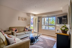 Relax in a cozy seating area with a sofa, chair, and flat-screen TV.