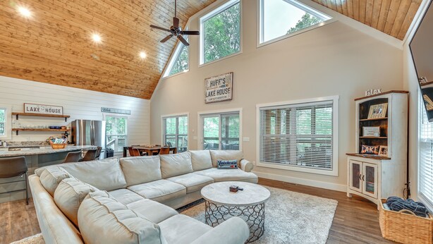 A spacious living room with a large L-shaped sectional sofa, a round coffee table, and a ceiling fan. - Luxe Kentucky Cabin Rental ~ 36 Mi to Mammoth Cave (Cub Run)