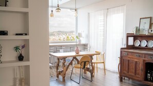 A modern kitchen with a wooden table, chairs, and a wooden cabinet with dishes. - Villa Celestina (Marco Simone)