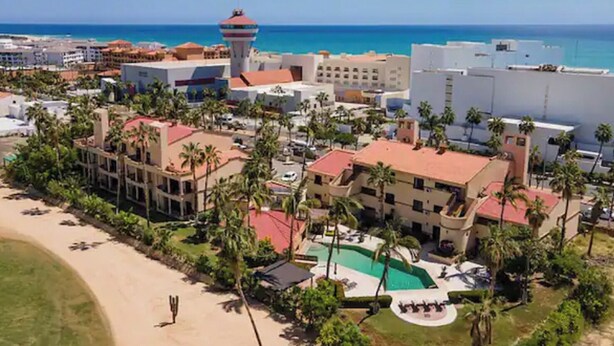 A resort with multiple buildings, a central pool, and a beach area. - Amplio Depa en San José del Cabo, Zona Hotelera, Hasta 8 Personas, Alberca (San José del Cabo)