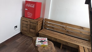 Un banc en bois et une boîte de six bouteilles de Coca-Cola dans un coin.