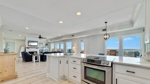 Una cocina moderna con armarios blancos, horno empotrado y una isla grande.