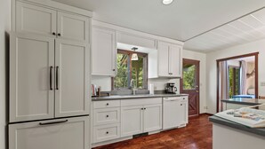 A kitchen with white cabinets, a wooden countertop, and a view of the outdoors. - RMR: Lake Creek Cottage Home in The Aspens (Wilson)