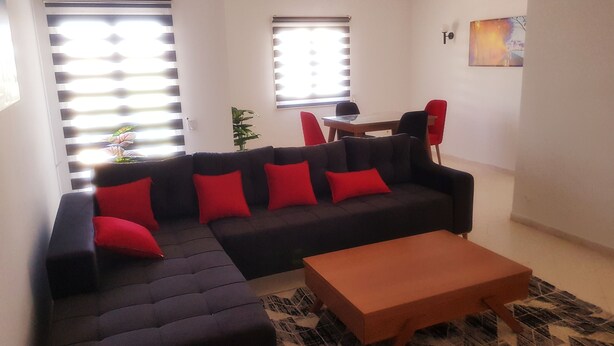 A living room with a sectional sofa, a coffee table, and a dining table with chairs.