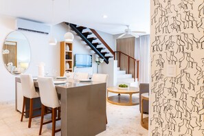 Um interior moderno com área de jantar, escada e sala de estar.