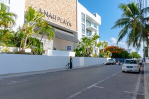 A street view with a building labeled 'AHN PLAYA' and a parking area with a bicycle.