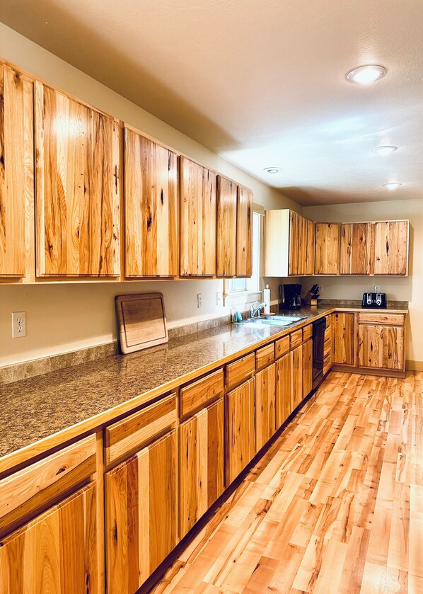 Enjoy cooking in this well-equipped kitchen with a central island, wooden cabinetry, and a stainless steel sink.