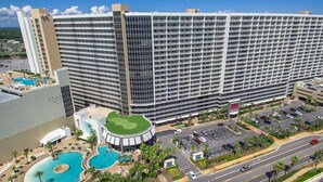 A large hotel with multiple floors, a central courtyard with a pool, and a parking area. - 5 Pools at this 1st Floor Condo with Beach Access at Laketown Wharf 119 (Panama City Beach)