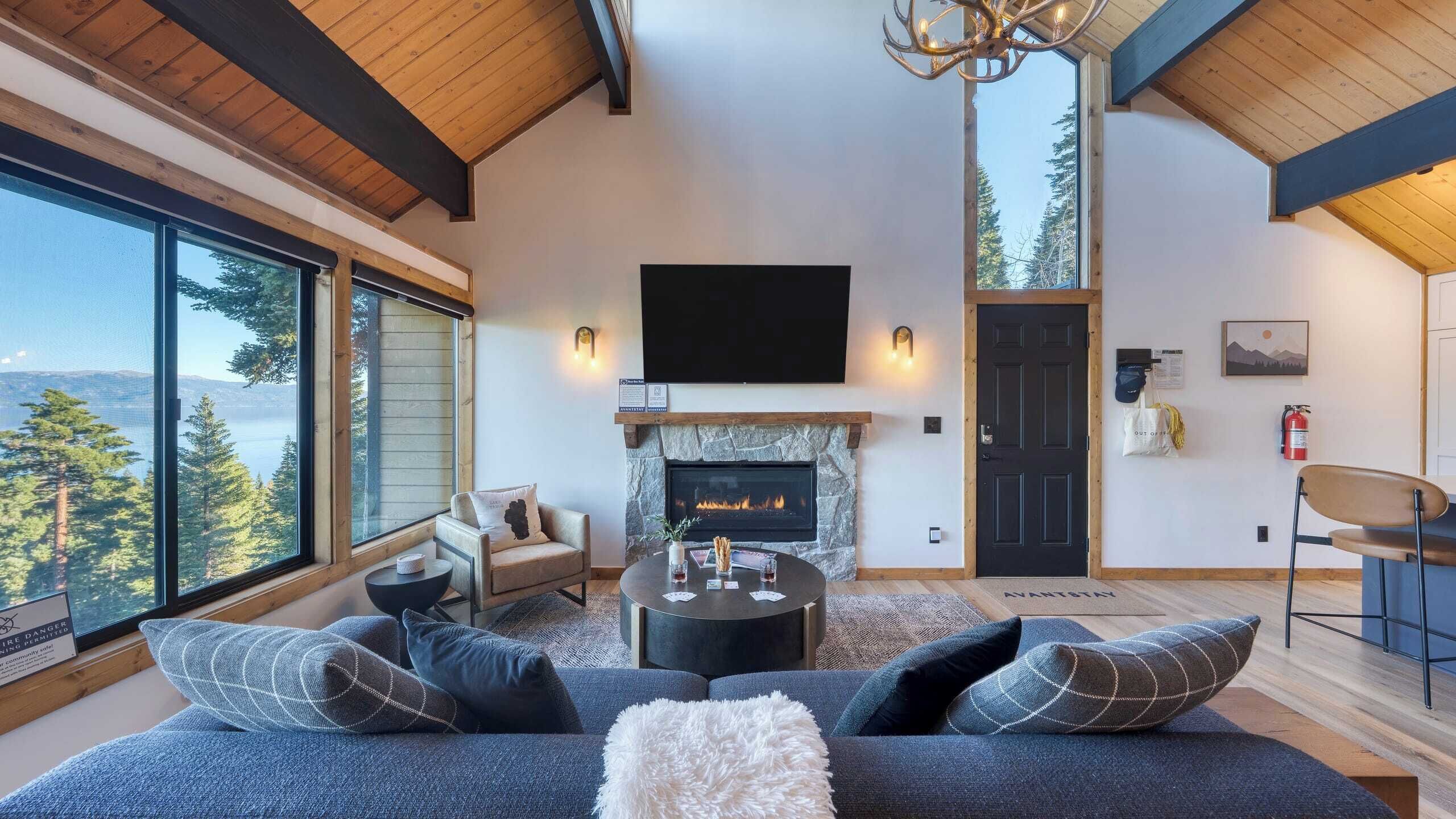 A spacious living room with a fireplace, large windows, and a cozy seating area.