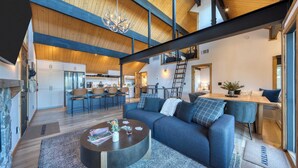 Ein modernes Wohnzimmer mit Sofa, Couchtisch und einer Küche im Hintergrund.