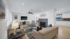 A modern living room with a fireplace, a sofa, a coffee table, and a TV.