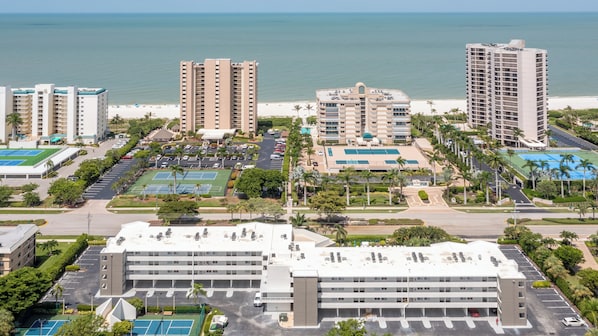Un hotel de altura con varios pisos, estacionamiento y vista a la playa.