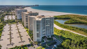 Un hôtel de grande hauteur doté d’un parking, offrant une vue sur la plage et situé à proximité d’une rivière.