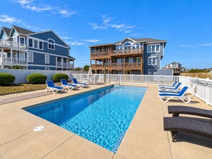 A swimming pool with lounge chairs and a wooden deck. - Seaducktion - Spacious, oceanfront home with panoramic views and Private Pool! (Duck)