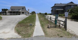 A beachfront property with a pathway leading to a gated entrance. - Lazy Days - Enjoy beautiful sunsets from this soundside home w/Private Pool! (Southern Shores)
