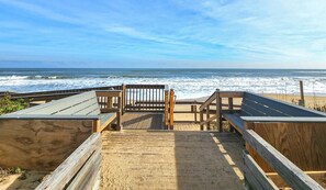 A wooden boardwalk leading to a beach with a bench and a sign indicating a short distance to the beach. - Lazy Days - Enjoy beautiful sunsets from this soundside home w/Private Pool! (Southern Shores)