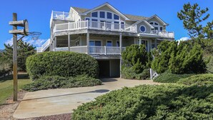 A large, two-story house with a balcony on the second floor, surrounded by well-maintained landscaping. - Sea & Ease - Enjoy superb ocean views and great beach access from this home w/Private Pool! (Southern Shores)