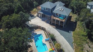 A two-story house with a swimming pool and a covered patio.