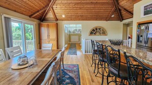A spacious kitchen with wooden cabinets, a granite countertop, and a dining area with a large table and chairs.