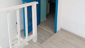 A white building with a blue door and a white railing. - Amazing Double Room N6784 in the Center (Tropea)