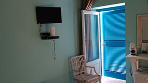 A room with two beds, a chair, a TV, and an air conditioning unit. - Amazing Double Room N6784 in the Center (Tropea)