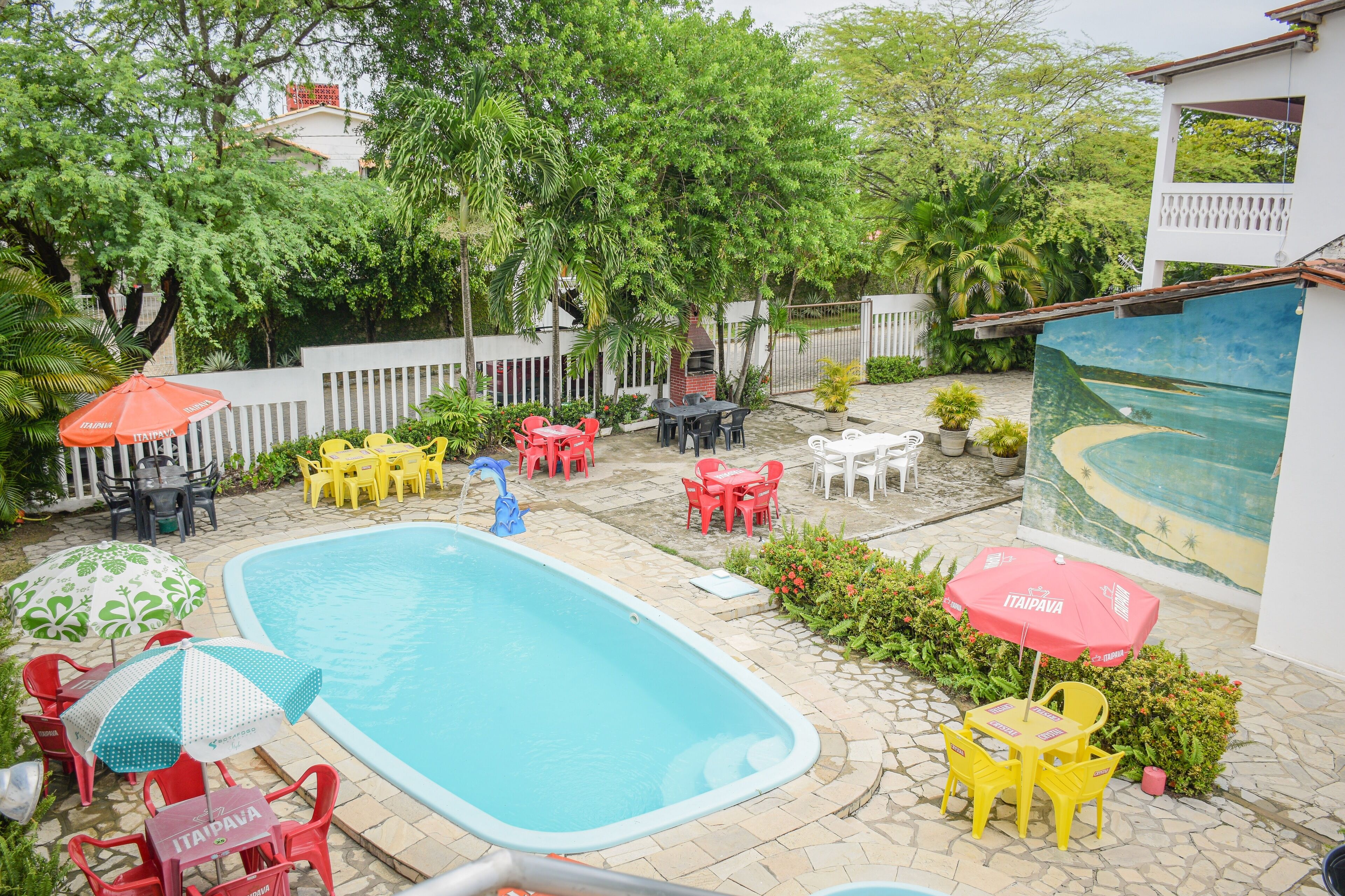 A swimming pool with surrounding patio furniture and a mural.