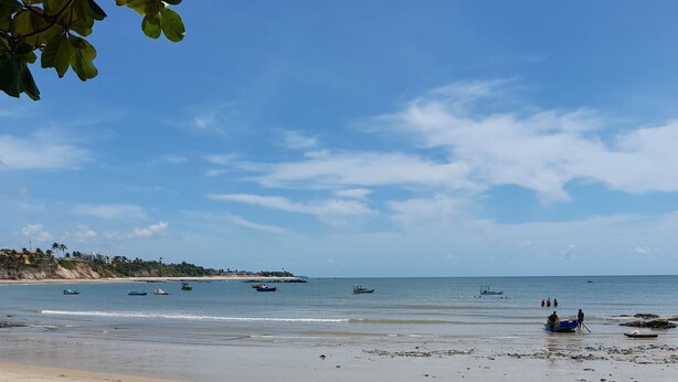 A beach with boats, a sandy shore, and a clear sky. - Pousada Passarela do Caranquejo pb (Conde)