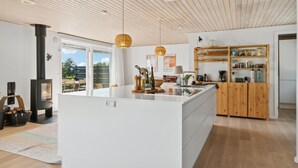 Una cocina moderna con una isla central, armarios de madera y una estufa integrada.