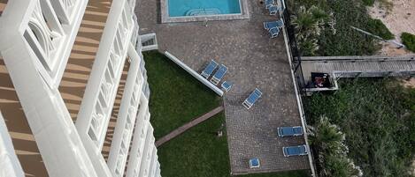 Vista aérea de un hotel con piscina rodeada de tumbonas, una terraza y una zona de playa.