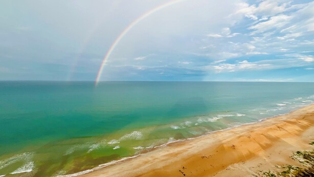 A beach with a rainbow over the ocean. - Oceanfront PENTHOUSE! Large Pool, Private Beach Access! Family Friendly!  (Ormond Beach)